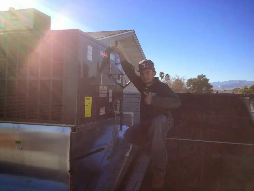 HVAC technician performing Boiler Repair on a rooftop unit in Buford